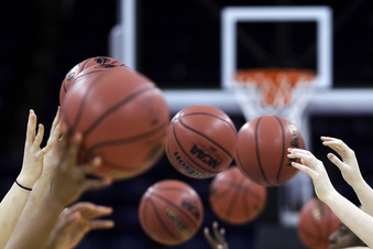 FILE -  Athletes toss basketballs in a drill at practice at the women's NCAA college basketball tournament, Friday, March 29, 2013, in Spokane, Wash. The Supreme Court's decision to overturn Roe v. Wade has added another complicated layer for college coaches to navigate. And, for some coaches, the constantly shifting landscape is making their profession more demanding than ever. (AP Photo/Elaine Thompson, File)