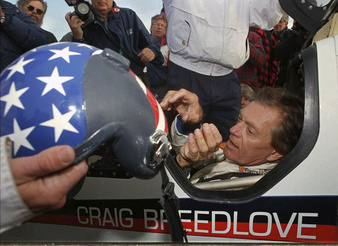 FILE -Former land speed record holder Craig Breedlove reaches for his helmet prior to making his first test run in his car "Spirit of America" Wednesday, Oct 23, 1996, in the Black Rock Desert near Gerlach Nev. Craig Breedlove, who set land-speed records by topping 400, 500 and 600 mph in jet-powered cars nicknamed Spirit of America, has died. He was 86. Breedlove died at his home in Rio Vista, California on April 4, 2023. (AP Photo/Rich Pedroncelli, File)