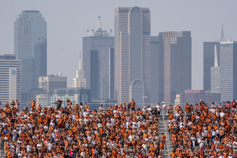FILE - The Dallas skyline rises behind the Cotton Bowl stands as Texas fans watch during the first half of an NCAA college football game against Oklahoma at the Cotton Bowl, Saturday, Oct. 8, 2022, in Dallas.  U.S. metropolitan areas increased their populations by almost half a percent last year in another sign that flight from urban areas during the first year of the pandemic either slowed down or reversed in its second year as people moved to Sunbelt metros in Texas and Florida by the tens of thousands. (AP Photo/Jeffrey McWhorter, File)