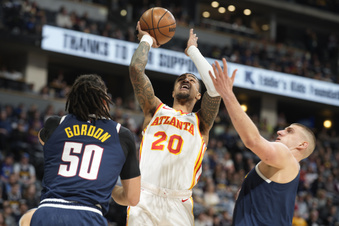 FILE - Atlanta Hawks forward John Collins, center, drives to the basket between Denver Nuggets forward Aaron Gordon, left, and center Nikola Jokic in the first half of an NBA basketball game Saturday, Feb. 4, 2023, in Denver. The Atlanta Hawks cleared significant salary cap space on Monday, June 26, by agreeing to trade forward John Collins to the Utah Jazz for veteran forward Rudy Gay and a future second-round draft pick, according to a person with knowledge of the deal. (AP Photo/David Zalubowski, File)