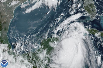 In this Monday, Aug. 28, 2023, 9:41 am ET satellite image provided by the National Oceanic and Atmospheric Administration, Tropical Storm Idalia moves between Mexico's Yucatan peninsula, left, and Cuba, right. Idalia intensified early Monday and was expected to become a major hurricane before it reaches Florida's Gulf coast, according to the National Hurricane Center.  (NOAA via AP)