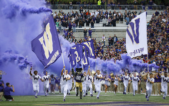 FILE - Washington cheerleaders and Harry, the Husky mascot, set off smoke effects as they lead the team out of the tunnel at Husky Stadium for Washington's home opener, an NCAA college football game against Montana, Saturday, Sept. 9, 2017, in Seattle. Dealing a crushing combination to the Pac-12 on Friday, Aug. 4, 2023, the Big Ten announced Oregon and Washington would be joining the conference next August, and the Big 12 completed its raid of the beleaguered league by adding Arizona, Arizona State and Utah.  (AP Photo/Ted S. Warren, File)