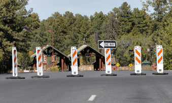 FILE - The Grand Canyon National Park entrance is blocked off, in Tusayan, Ariz., Oct. 8, 2013, because of a partial government shutdown. Arizona's Grand Canyon National Park and all five national parks in Utah will remain open if the U.S. government shuts down, Sunday, Oct. 1, 2023. Arizona Gov. Katie Hobbs and Utah Gov. Spencer Cox say that the parks are important destinations and local communities depend on dollars from visitors. (AP Photo/Matt York, File)