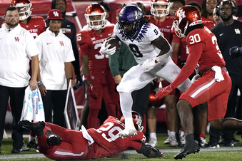 TCU's Emani Bailey (9) runs for a gain as Houston's Trimarcus Cheeks (30) and Treylin Payne (29) defend during the second half of an NCAA college football game Saturday, Sept. 16, 2023, in Houston. (AP Photo/David J. Phillip)