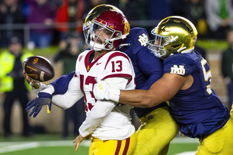 Southern California quarterback Caleb Williams (13) attempts to throw the ball as Notre Dame linebacker Jaylen Sneed, center, and defensive lineman Howard Cross III, right, pressure him during the second half of an NCAA college football game against Southern California Saturday, Oct. 14, 2023, in South Bend, Ind. (AP Photo/Michael Caterina)