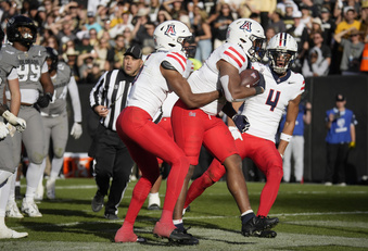 Arizona running back DJ Williams, center, is congratulated after scoring a touchdown by wide receivers Montana Lemonious-Craig, left, and Tetairoa McMillan in the second half of an NCAA college football game against Colorado on Saturday, Nov. 11, 2023, in Boulder, Colo. (AP Photo/David Zalubowski)