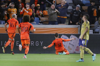 Corey Baird, del Dynamo de Houston, se desliza de rodillas para festejar su gol ante el Real Salt Lake, en un partido de los playoffs de la MLS, disputado, el sábado 11 de noviembre de 2023 (AP Foto/Michael Wyke)