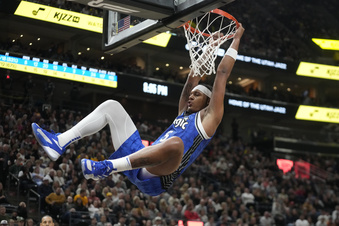 Orlando Magic forward Paolo Banchero hangs from the rim after dunking against the Utah Jazz during the first half of an NBA basketball game Thursday, Nov. 2, 2023, in Salt Lake City. (AP Photo/Rick Bowmer)