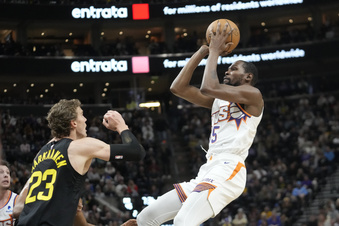 Phoenix Suns forward Kevin Durant shoots as Utah Jazz forward Lauri Markkanen (23) defends during the first half of an NBA basketball game, Sunday, Nov. 19, 2023, in Salt Lake City. (AP Photo/Rick Bowmer)