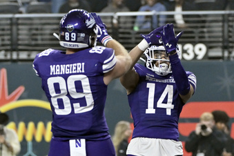 Northwestern tight end Charlie Mangieri (89) and wide receiver Cam Johnson (14) celebrate after Johnson's touchdown against Utah during the first half of the Las Vegas Bowl NCAA college football game, Saturday, Dec. 23, 2023, in Las Vegas. (AP Photo/David Becker)