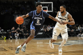 BYU guard Jaxson Robinson (2) drives past Central Florida guard Darius Johnson, right, during the second half of an NCAA college basketball game, Saturday, Jan. 13, 2024, in Orlando, Fla. (AP Photo/John Raoux)