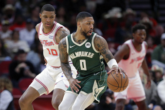Milwaukee Bucks guard Damian Lillard (0) spins on a drive in front of Houston Rockets forward Jabari Smith Jr. (10) during the first half of an NBA basketball game Saturday, Jan. 6, 2024, in Houston. (AP Photo/Michael Wyke)