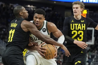 Milwaukee Bucks' Giannis Antetokounmpo tries to get past Utah Jazz's Kris Dunn and Lauri Markkanen during the first half of an NBA basketball game Monday, Jan. 8, 2024, in Milwaukee. (AP Photo/Morry Gash)