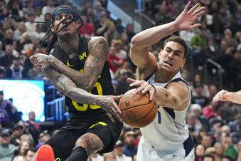 Utah Jazz guard Jordan Clarkson, left, drives to the basket as Dallas Mavericks center Dwight Powell defends during the second half of an NBA basketball game Monday, Jan. 1, 2024, in Salt Lake City. (AP Photo/Rick Bowmer)