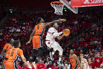 Utah guard Deivon Smith, center right, leaps to the basket while guarded by Oregon State guard Justin Rochelin, center left, during the second half of an NCAA college basketball game Thursday, Jan. 18, 2024, in Salt Lake City. (AP Photo/Isaac Hale)