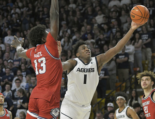 Utah State forward Great Osobor (1) shoots the ball as Fresno State center Enoch Boakye (13) defends during the second half of an NCAA college basketball game Saturday, Jan. 20, 2024, in Logan, Utah. (Eli Lucero/The Herald Journal via AP)