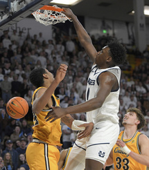 Utah State forward Great Osobor dunks as Wyoming forward Caden Powell and forward Mason Walters (33) defend during the first half of an NCAA college basketball game Tuesday, Jan. 9, 2024, in Logan, Utah. (Eli Lucero/The Herald Journal via AP)