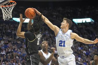BYU guard Trevin Knell (21) blocks the shot of Central Florida guard DeMarr Langford Jr. (12) during the first half of an NCAA college basketball game Tuesday, Feb. 13, 2024, in Provo, Utah. (AP Photo/Rick Bowmer)