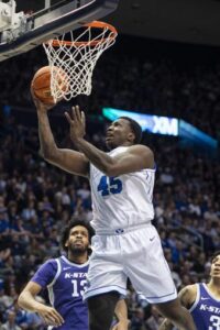BYU forward Fousseyni Traore (45) lays the ball up past Kansas State forward Will McNair Jr., left, and guard Dorian Finister during the second half of an NCAA college basketball game Saturday, Feb. 10, 2024, in Provo, Utah. (AP Photo/Isaac Hale)