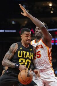 Utah Jazz forward John Collins (20) drives against Atlanta Hawks center Clint Capela (15) during the first half of an NBA basketball game Tuesday, Feb. 27, 2024, in Atlanta. (AP Photo/Hakim Wright Sr.)