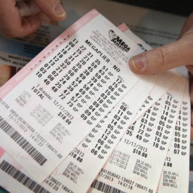 CHICAGO, IL - DECEMBER 17:  A customer holds a stack of Mega Millions lottery tickets which he purchased for his office pool at a convenience store on December 17, 2013 in Chicago, Illinois. The jackpot is currently the second largest in U.S. history.  (Photo Illustration by Scott Olson/Getty Images)