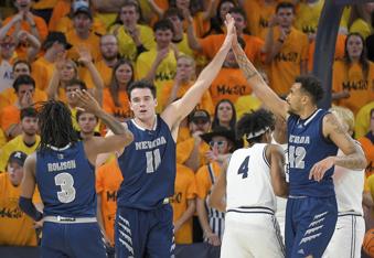 Nevada forward Nick Davidson (11) celebrates with guard Tyler Rolison (3) and forward K.J. Hymes (42) after making a basket while being fouled against Utah State during the second half of an NCAA college basketball game Tuesday, Feb. 6, 2024, in Logan, Utah. (Eli Lucero/Herald Journal via AP)