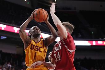 Southern California guard Isaiah Collier, left, shoots as Utah center Lawson Lovering defends during the first half of an NCAA college basketball game Thursday, Feb. 15, 2024, in Los Angeles. (AP Photo/Mark J. Terrill)