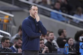 Utah State head coach Danny Sprinkle is seen on the sidelines during the first half of a second-round college basketball game against Purdue in the NCAA Tournament, Sunday, March 24, 2024 in Indianapolis. (AP Photo/Michael Conroy)