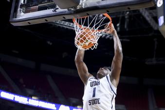 Utah State forward Great Osobor (1) dunks against Fresno State during the first half of an NCAA college basketball game in the quarterfinal round of the Mountain West Conference tournament, Thursday, March 14, 2024, in Las Vegas. (AP Photo/Ian Maule)