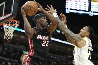 Miami Heat forward Jimmy Butler (22) looks to pass as Utah Jazz forward John Collins (20) defends during the first half of an NBA basketball game, Saturday, March 2, 2024, in Miami. (AP Photo/Lynne Sladky)