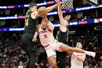 Houston Rockets forward Dillon Brooks (9) passes the ball as Utah Jazz center Walker Kessler, left, and forward Micah Potter, right, defend during the first half of an NBA basketball game Saturday, March 23, 2024, in Houston. (AP Photo/Eric Christian Smith)