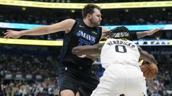 Utah Jazz forward Taylor Hendricks (0) tries to get past Dallas Mavericks guard Luka Doncic (77) during the first half of an NBA basketball game in Dallas, Thursday, March 21, 2024. (AP Photo/LM Otero)