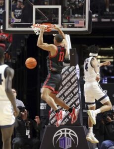 San Diego State forward Jaedon LeDee (13) dunks against Utah State during the first half of an NCAA college basketball game in the semifinals of the Mountain West Conference men's tournament Friday, March 15, 2024, in Las Vegas. (AP Photo/Ronda Churchill)