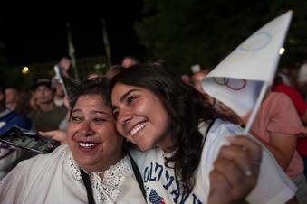 Patricia Huhem, left, and her daughter, Elisa Huhem, celebrate while watching a live feed from Paris moments after the International Olympic Committee awarded Salt Lake City the 2034 Winter Olympics, Wednesday, July 24, 2024, in Salt Lake City. (AP Photo/Spenser Heaps)