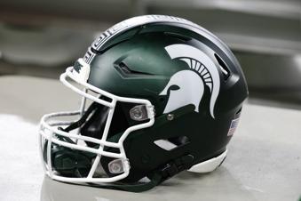 FILE - A Michigan State football helmet is seen during an NCAA college football game against Penn State on Nov. 24, 2023, in Detroit.  Three years into the new age of college sports, where athletes are allowed to profit from their successes through name, image and likeness deals, everyone is still trying to find out what the new normal will be. (AP Photo/Al Goldis, File)