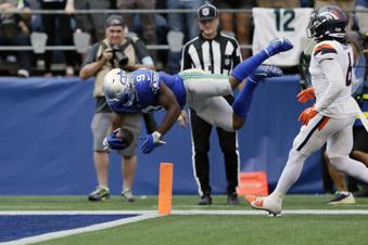 Seattle Seahawks running back Kenneth Walker III (9) leaps into the endzone for a touchdown during the second half of an NFL football game against the Denver Broncos, Sunday, Sept. 8, 2024, in Seattle. (AP Photo/John Froschauer)