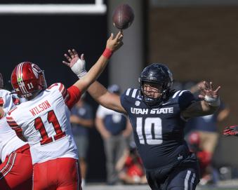 Utah quarterback Isaac Wilson (11) throws the ball as Utah State defensive tackle Gabriel Iniguez Jr. (10) defends in the first half of an NCAA college football game Saturday, Sept. 14, 2024, in Logan, Utah. (Eli Lucero/The Herald Journal via AP)
