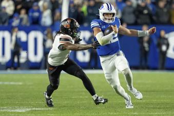 BYU quarterback Jake Retzlaff runs the ball ahead of Oklahoma State cornerback Korie Black in the second half of an NCAA college football game, Friday, Oct. 18, 2024, in Provo, Utah. (AP Photo/Spenser Heaps)