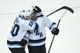 Utah Hockey Club's Sean Durzi, left, and Clayton Keller, right, react after Keller scored the winning goal during overtime of an NHL hockey game against the New York Rangers, Saturday, Oct. 12, 2024, in New York. (AP Photo/Pamela Smith)