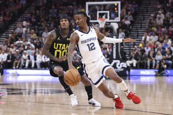 Memphis Grizzlies guard Ja Morant (12) dribbles past Utah Jazz guard Jordan Clarkson (00) during the first half of an NBA basketball game, Wednesday, Oct. 23, 2024, in Salt Lake City. (AP Photo/Rob Gray)