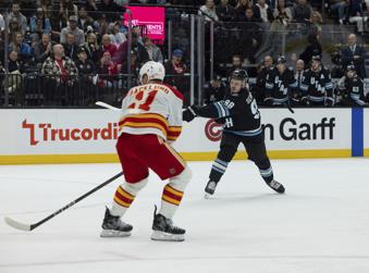 Utah Hockey Club defenseman Mikhail Sergachev (98) shoots the puck to score against Calgary Flames center Mikael Backlund (11) during the second period of an NHL hockey game, Wednesday, Oct. 30, 2024, in Salt Lake City. (AP Photo/Melissa Majchrzak)