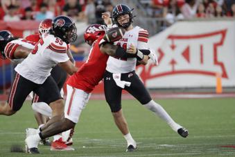 Utah quarterback Isaac Wilson, left, loses the ball as he's sacked by Houston linebacker Latreveon McCutchin, center, as offensive lineman Spencer Fano (55) closes in during the first half of an NCAA college football game Saturday, Oct. 26, 2024, in Houston. (AP Photo/Michael Wyke)