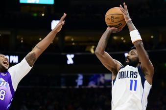 Dallas Mavericks guard Kyrie Irving (11) looks to shoot over Utah Jazz forward Brice Sensabaugh, left, during the first half of an NBA basketball game Saturday, Nov. 30, 2024, in Salt Lake City. (AP Photo/Tyler Tate)