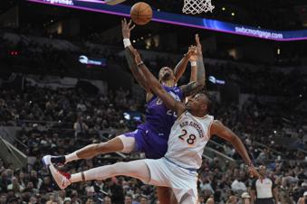 Utah Jazz forward John Collins, top, is blocked by San Antonio Spurs center Charles Bassey (28) as he drives to the basket during the second half of an NBA basketball game in San Antonio, Thursday, Nov. 21, 2024. (AP Photo/Eric Gay)