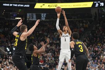 San Antonio Spurs center Victor Wembanyama (1) shoots as Utah Jazz guard Keyonte George (3), center Walker Kessler (24) and guard Collin Sexton (2) defend during the second half of an NBA basketball game, on Tuesday, Nov. 26, 2024, in Salt Lake City. (AP Photo/Bethany Baker)