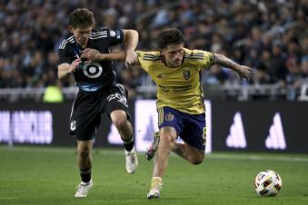Minnesota United midfielder Will Trapp (20) and Real Salt Lake midfielder Diego Luna (8) vie for the ball during the second half of a first-round soccer match of the MLS Cup playoffs in St. Paul, Minn., Saturday, Nov. 2, 2024. (AP Photo/Ellen Schmidt)
