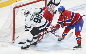 Utah Hockey Club's Mikhail Sergachev (98) scores against Montreal Canadiens goaltender Sam Montembeault as Canadiens' Jake Evans (71) defends during overtime NHL hockey action in Montreal, Tuesday, Nov. 26, 2024. (Graham Hughes/The Canadian Press via AP)