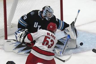 Utah Hockey Club goaltender Karel Vejmelka (70) makes a save against Carolina Hurricanes right wing Jackson Blake (53) during the third period of an NHL hockey game Wednesday, Nov. 13, 2024, in Salt Lake City. (AP Photo/Rick Bowmer)