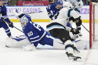 Toronto Maple Leafs goaltender Joseph Woll (60) makes a save against Utah Hockey Club left wing Michael Carcone (53) during third-period NHL hockey game action in Toronto, Sunday, Nov. 24, 2024. (Frank Gunn/The Canadian Press via AP)