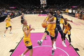 Iowa forward Owen Freeman (32) and Utah State guard Ian Martinez (4) battle for a rebound during the second half of an NCAA college basketball game, Friday, Nov. 22, 2024, in Kansas City, Mo. (AP Photo/Charlie Riedel)
